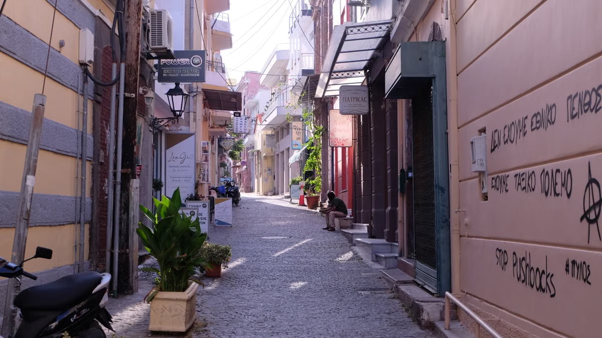 Cobblestone street with street art and plants in a vibrant European alleyway.